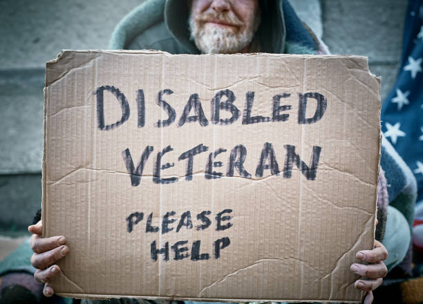 A disabled veteran begs for help in the street.